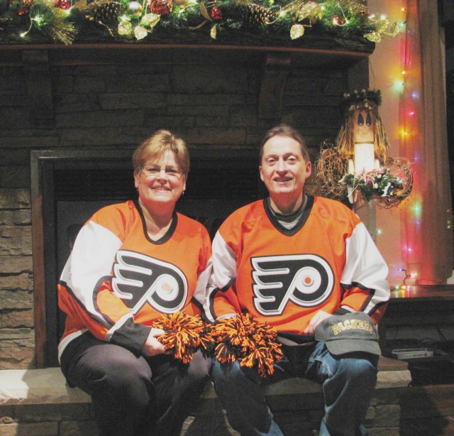 George & I in our hockey jerseys at Thanksgiving in front of our fire place in our new great room